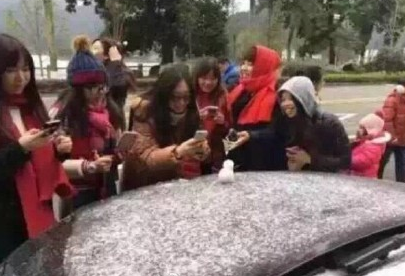 广州建国来首下雪 市民争相对扁平“雪人”拍照