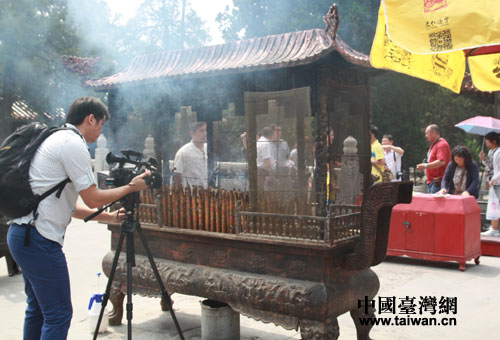 湾UDNTV记者在记录香客上香画面。