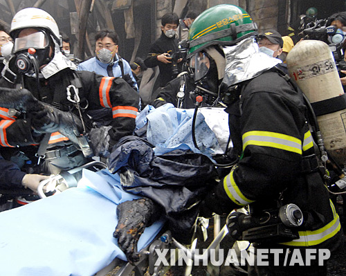 1月7日,在韩国京畿道利川市,消防员从爆炸现场抬出一具尸体。