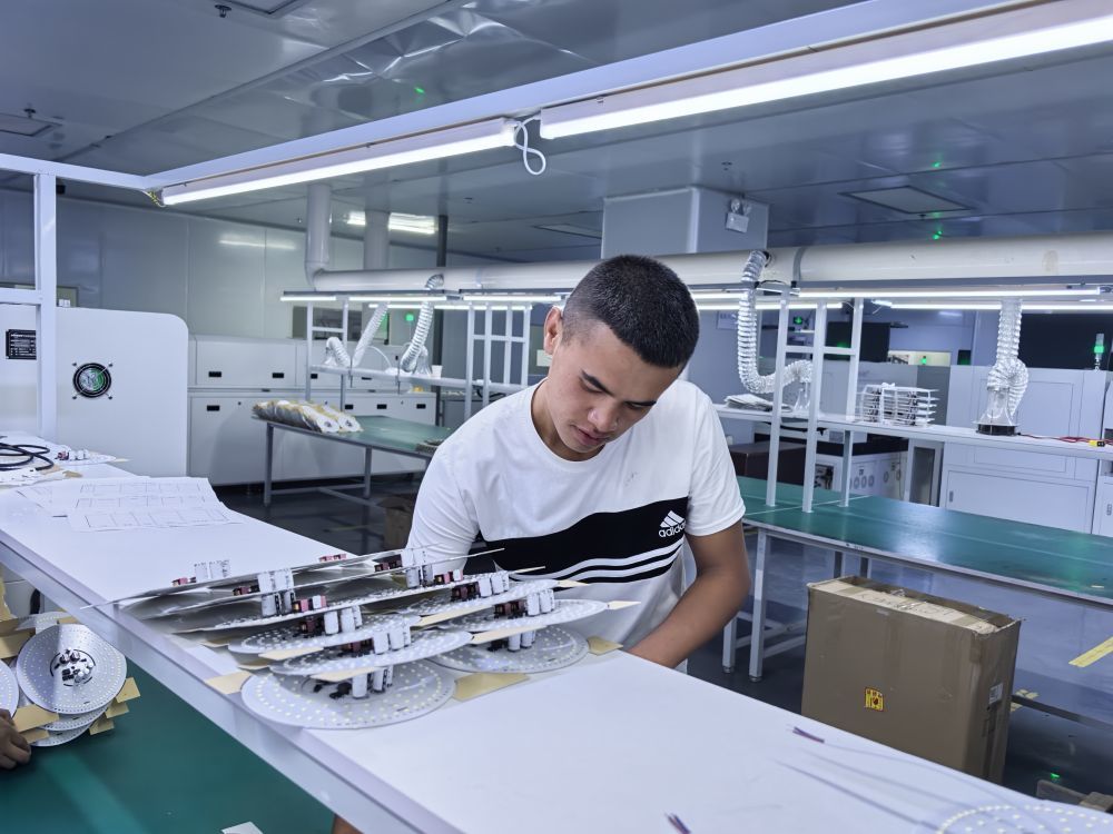 6月24日,新疆领航新能源科技发展有限公司的员工正在组装灯具。(新华社记者 顾煜 摄)