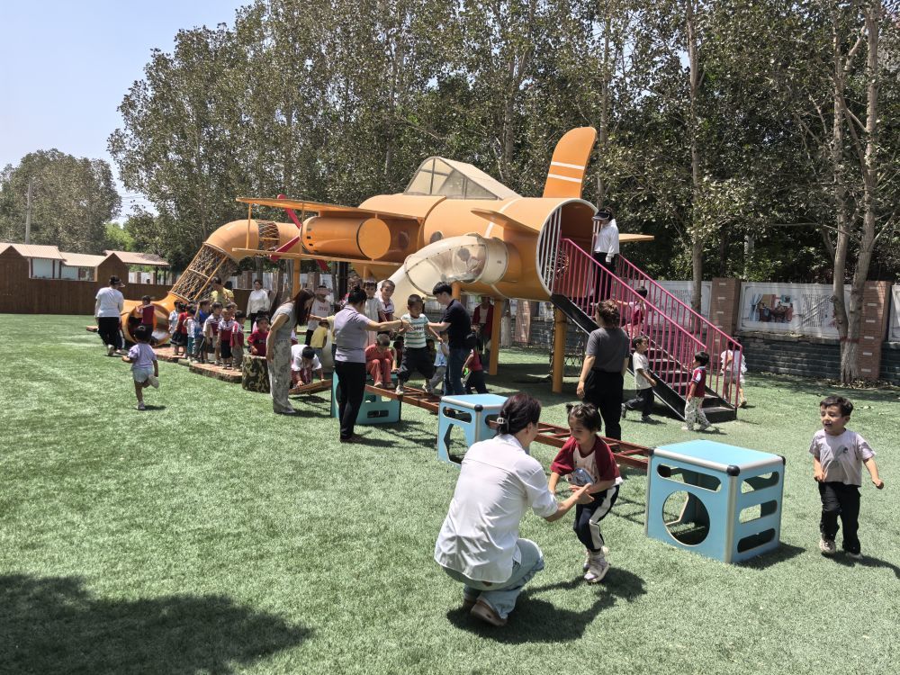 6月24日,在疏勒县第二幼儿园内,东营市援疆老师正带着孩子们进行户外活动。(新华社记者 顾煜 摄)