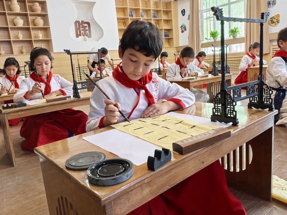 6月26日,在泰安市对口支援的岳普湖县艾西曼镇一小学内,孩子们正在学习书法。(新华社记者 顾煜 摄)