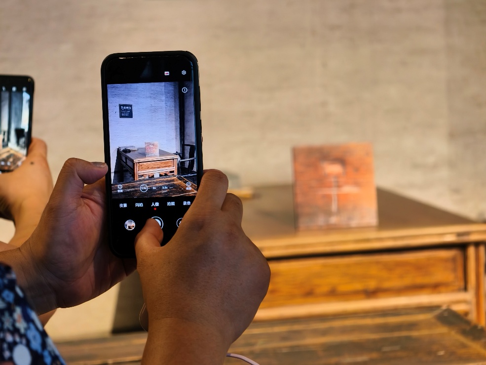 2025年7月15日,暑期研学团小朋友在浙江省绍兴市三味书屋拍摄鲁迅读书座位及课桌上的“早”字。受访者供图