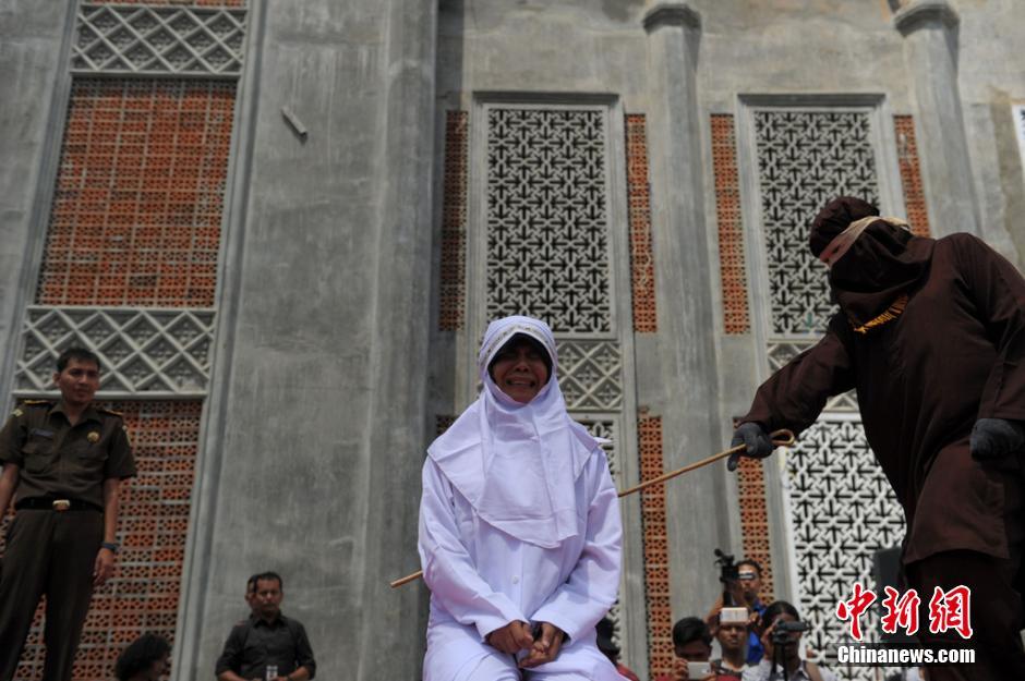 印尼妇女因婚外情遭当众鞭笞 民众围观拍照