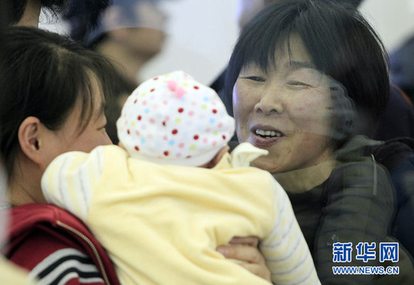 在日本大阪关西国际机场出境航班安检口,一名女子抱着孩子送别亲人