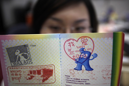 昨天是母亲节,一位游客正在展示她盖过"我爱妈妈"专用章的世博护照.
